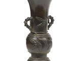 un vase en bronze posé sur un socle