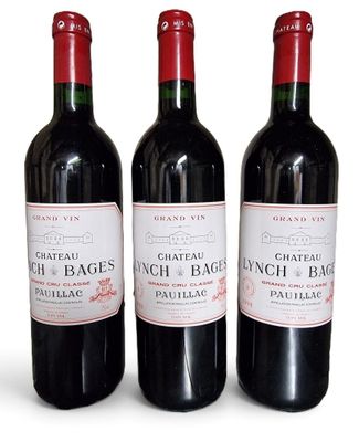 three bottles of red wine sitting next to each other on a white surface