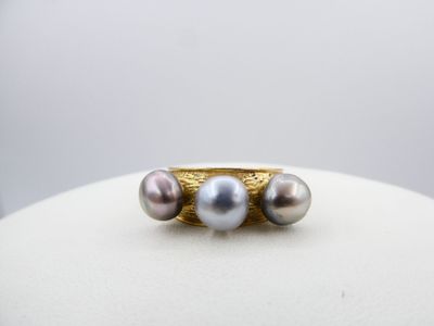 an image of a gold ring with three pearls on top of it