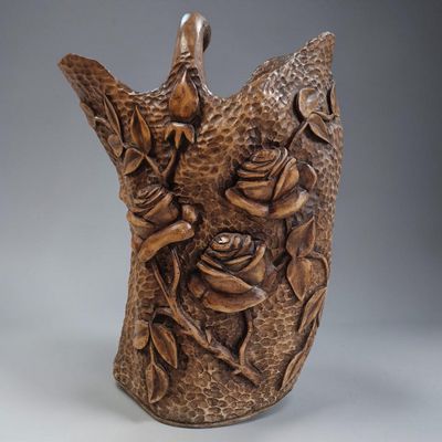 un vase marron orné d'un oiseau et de fleurs