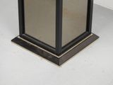 a black and gold pedestal with a mirror on it