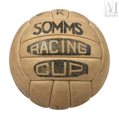 un vieux ballon de foot sur lequel est inscrit « Racing Cup »