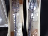 two forks and spoons in a box on a table