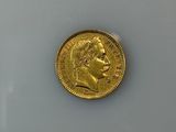 a close up of a gold coin on a white surface