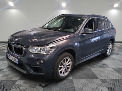 La BMW X1 est garée dans le garage, sur un sol à damier.