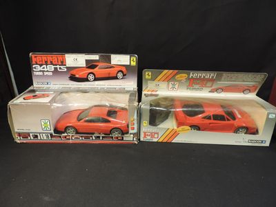 two red toy cars are sitting side by side on a black surface
