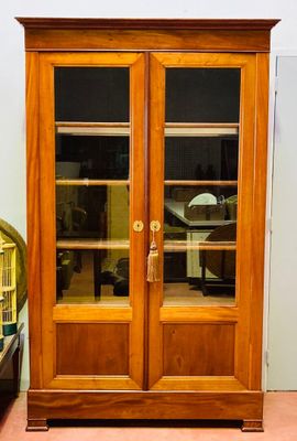 a large wooden cabinet with glass doors in a room