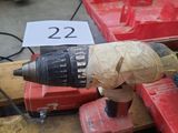une perceuse posée sur une boîte rouge