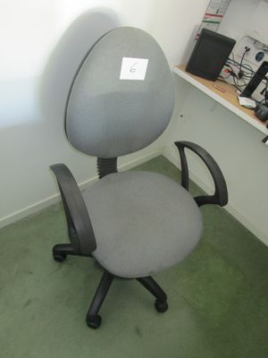 une chaise de bureau grise dans un coin d'une pièce