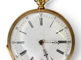 une montre de poche en or avec des chiffres romains sur le cadran