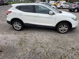 a picture of a white nissan suv in a parking lot