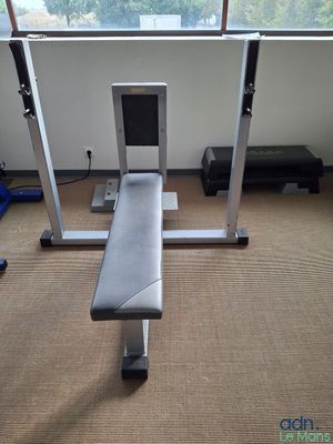 un banc au milieu d'une salle de sport, avec vue sur l'extérieur