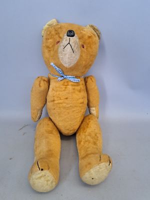 un ours en peluche marron avec un nœud bleu autour du cou