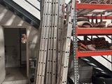 a stack of metal shelves in a garage next to a staircase