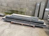 several pieces of steel are stacked on pallets in a warehouse