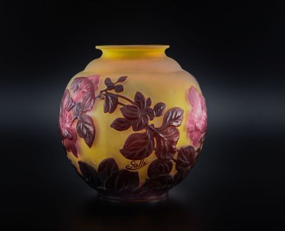 un vase jaune orné de fleurs rouges, posé sur un fond noir