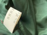 a label on a green jacket with a black and white tag