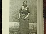 a black and white photo of a woman standing in front of a cake