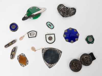 un assortiment de broches et de bijoux variés, présentés sur un fond blanc