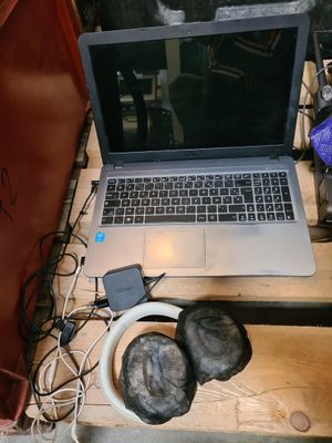 a laptop computer sitting on a wooden table with headphones around it
