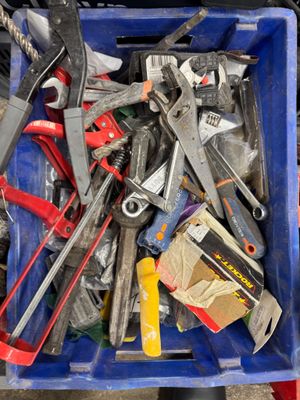 a blue bin full of tools sitting on the ground