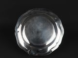 an antique silver plate on a black background with a black background