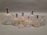 several bottles of perfume are lined up in a row on a white surface