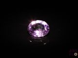 a close up of a purple diamond on a black surface
