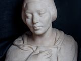 une statue représentant une femme les mains posées sur ses genoux