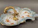 a blue and gold plate with a handle on it