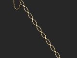 a close up of a gold bracelet with a chain on a black background