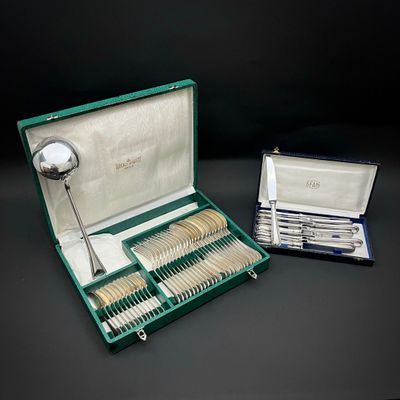 un coffret vert contenant de l'argenterie sur une table