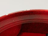 a red plate with a blue flower on it