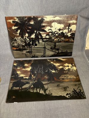 Deux œuvres d'art sont posées sur une chaise dans une pièce