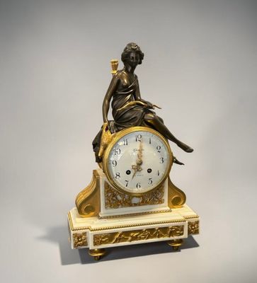 une horloge en or avec une femme assise dessus