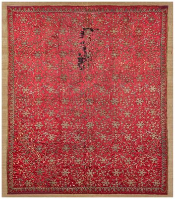 un tapis oriental à fond rouge et bordure dorée