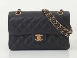 un sac Chanel noir avec des finitions dorées et une chaîne