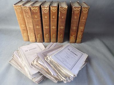 Plusieurs vieux livres sont empilés les uns sur les autres sur un lit