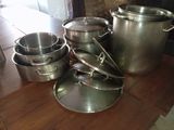 many pots and pans sitting on a wooden table