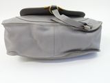 grey leather handbag on white background with strap and handle