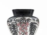 a black and white vase with pink flowers on it