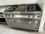une cuisine équipée d'une cuisinière, d'un four et de placards