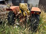 un tracteur garé dans l'herbe devant un bâtiment