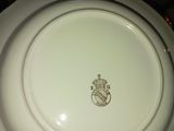 une assiette blanche ornée d'un blason royal