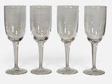 trois verres à vin vides posés l'un à côté de l'autre sur une surface blanche
