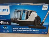emballage d'un aspirateur Philips posé sur une table en bois
