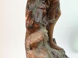 bronze statue of a boy holding a bird on a rock