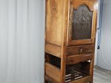 a wooden cabinet with a door and a shelf on top of it