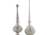 deux vases en argent posés l'un à côté de l'autre sur une surface blanche