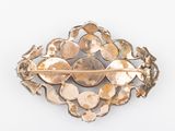 a close up of a gold broochle on a white surface